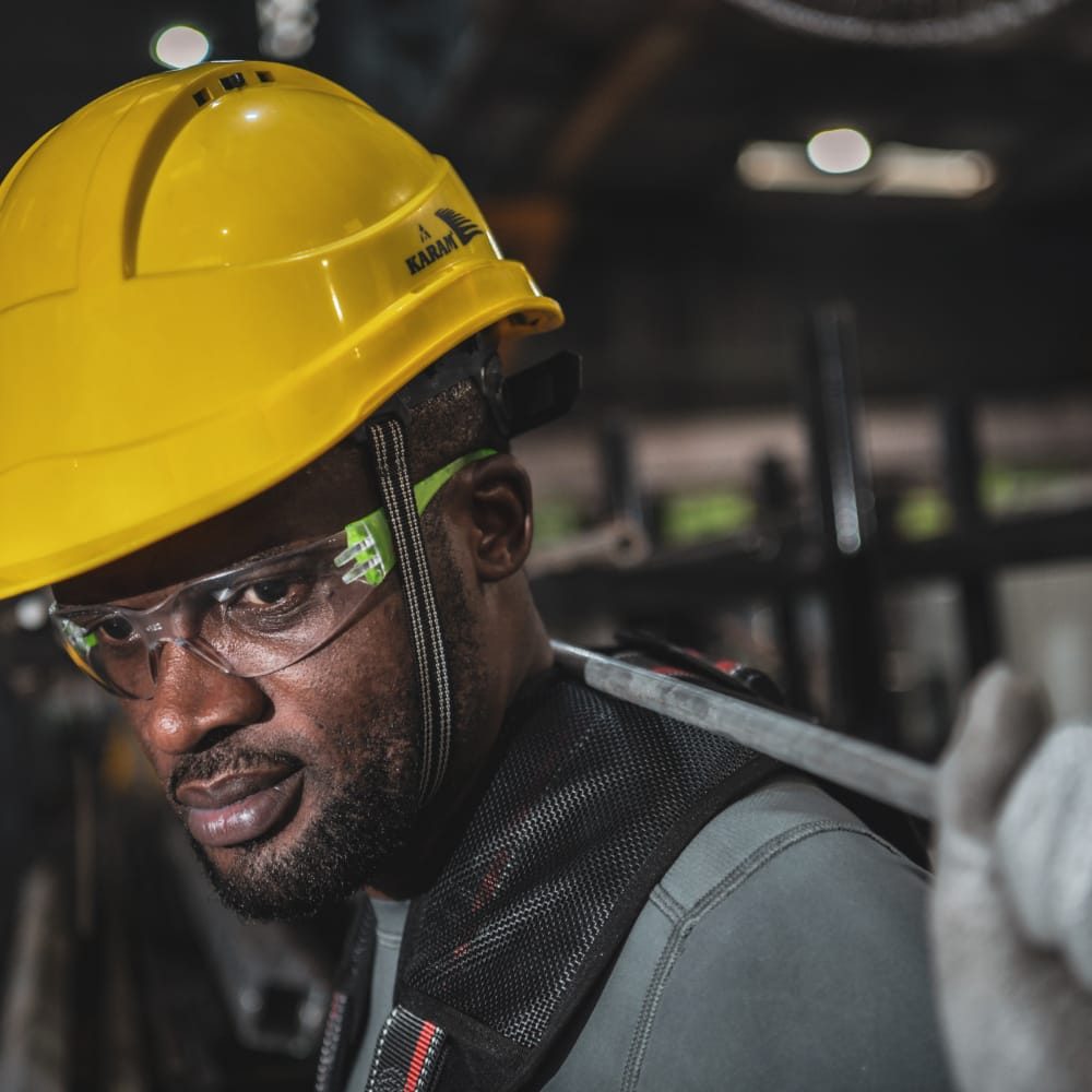 Worker wearing a yellow hard hat and safety glasses